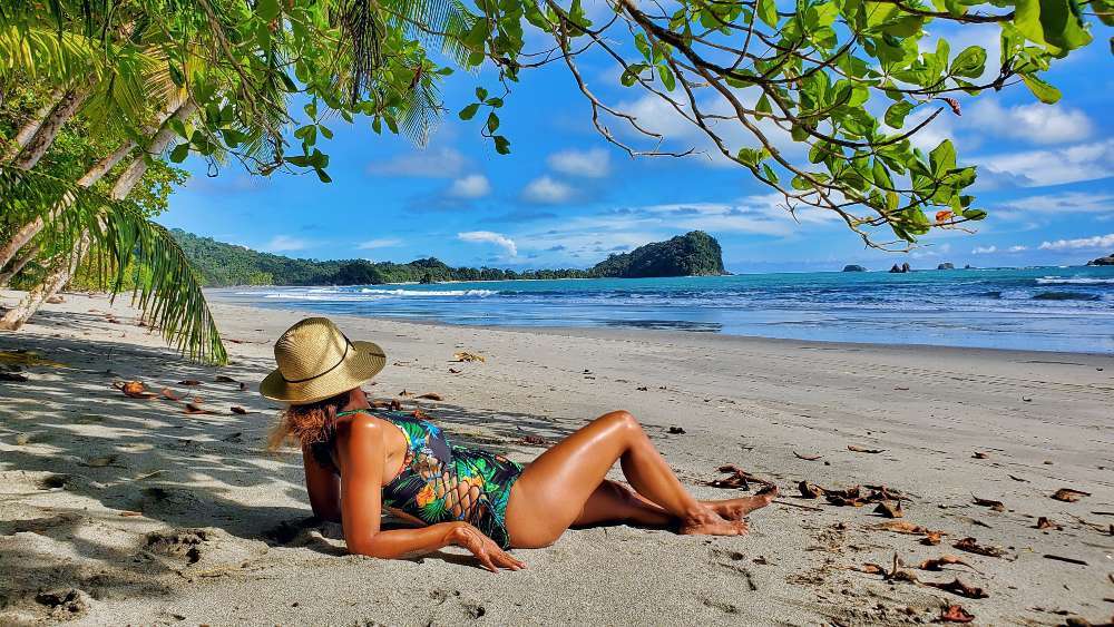 A woman with toes in the sand low tide at Playa Playitas Beach Manuel Antonio Costa Rica